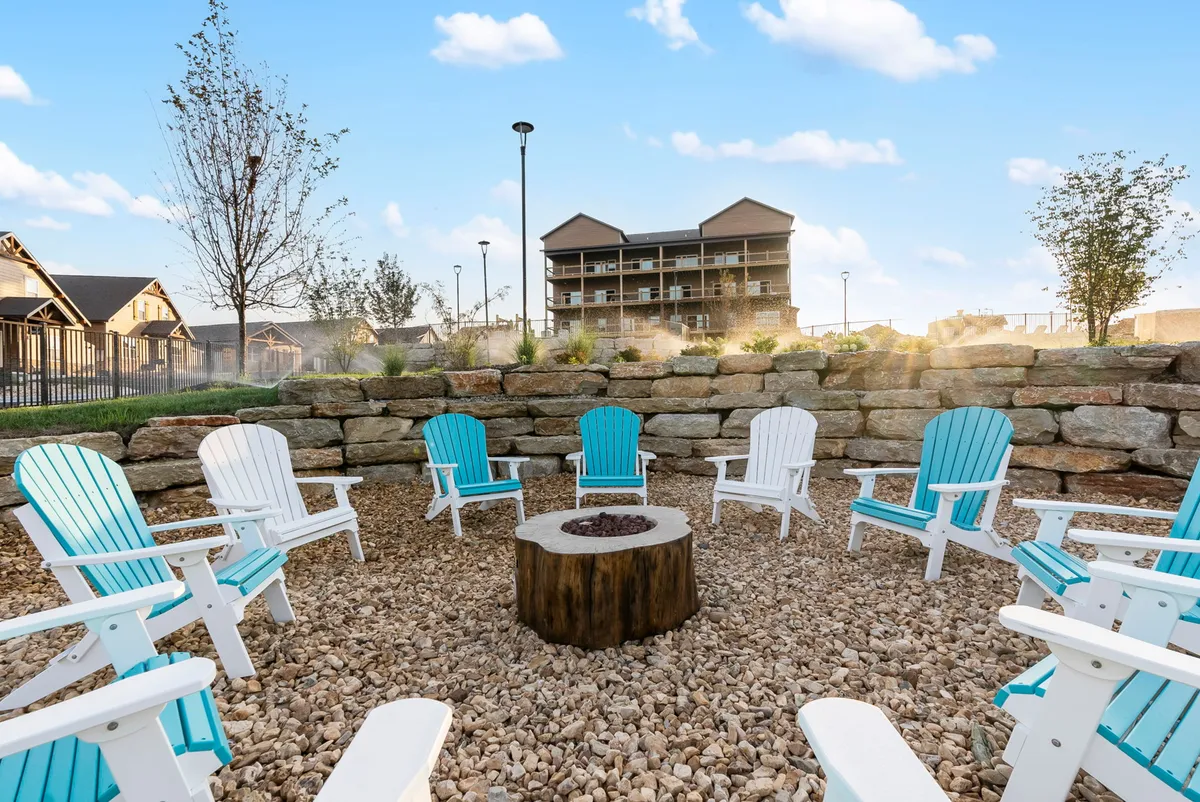 This exterior shot features a cozy fire pit surrounded by Adirondack chairs and tasteful landscaping, ideal for evening gatherings and relaxing under the stars. The setting suggests warmth, community, and the inviting resort lifestyle.